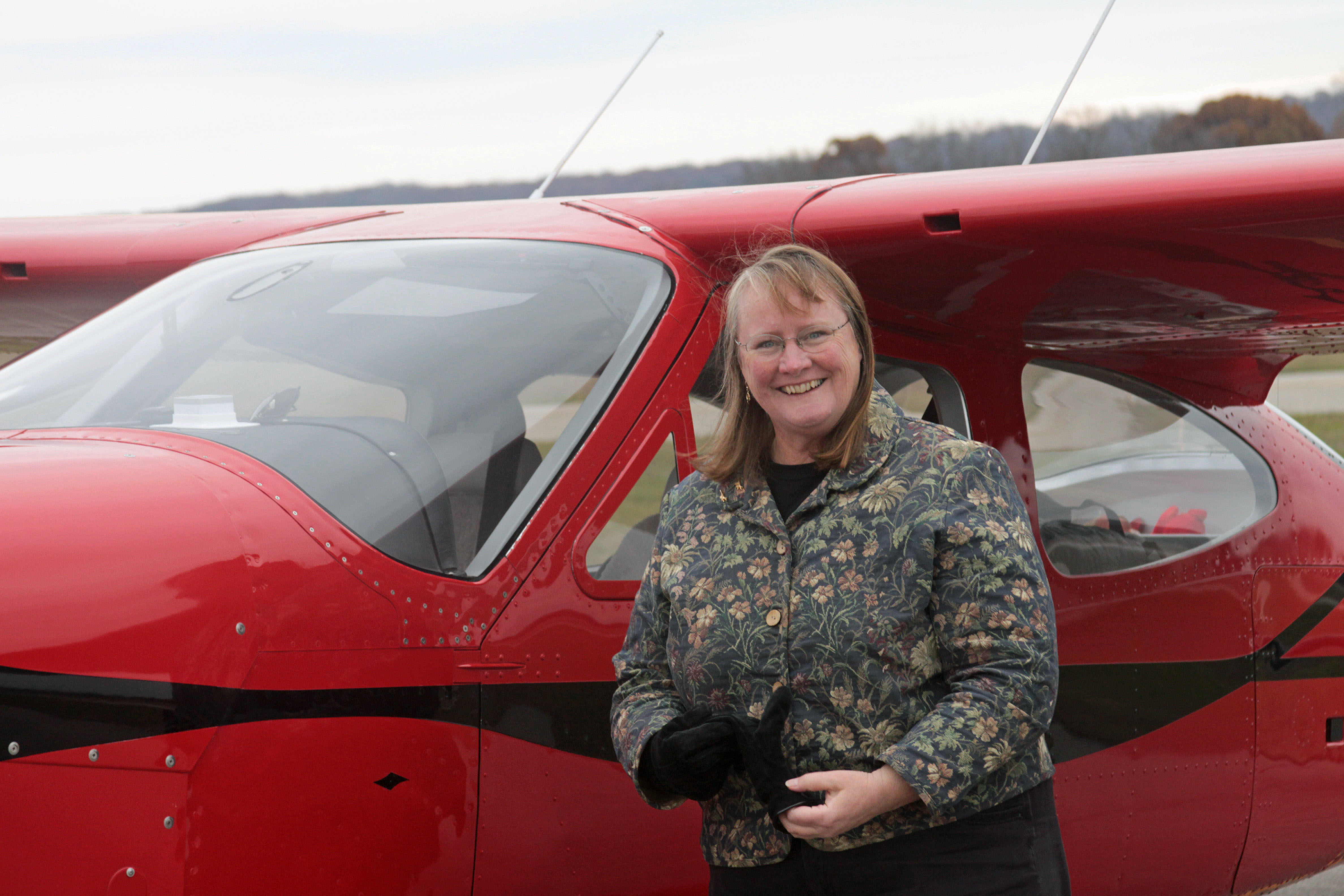 Kathy Vesely in front of small red plane