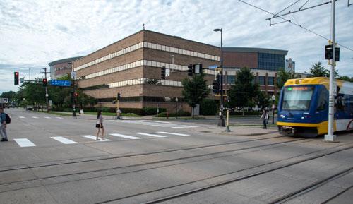 Photo of office building with light rail train crossing intersection